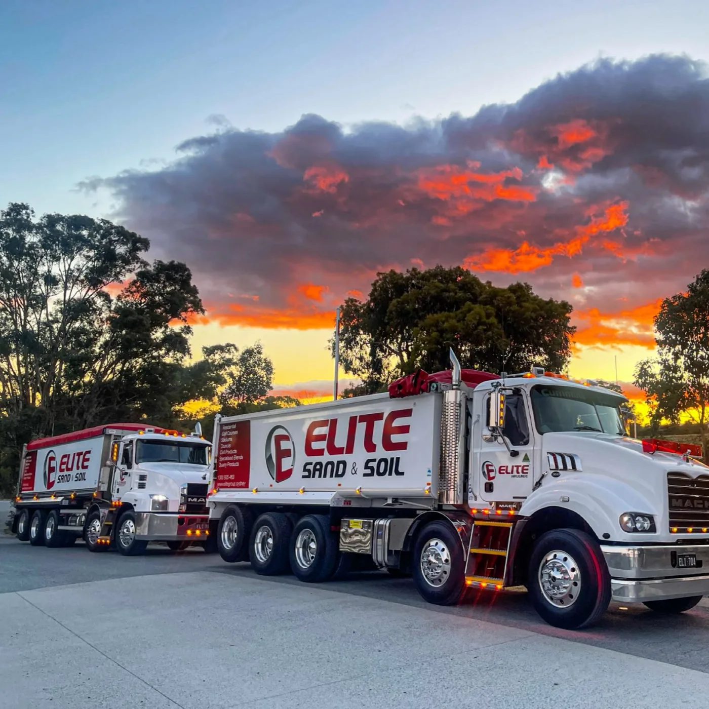 Two new Mack rigid tippers in Elite livery lined up at sunset