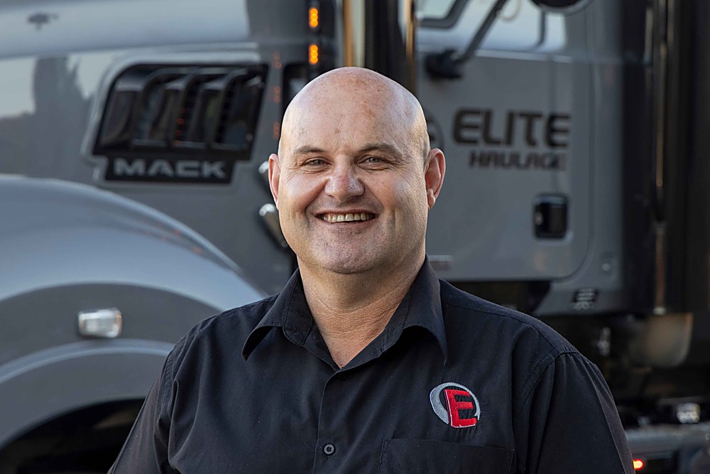 Jason Roberts, Founder and Managing Director of Elite Haulage, in front of an Elite truck